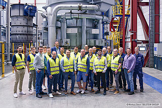 Foto (Markus Steur, Bilstein Group): Mitarbeiter der Bilstein Group und der beteiligten Firmen zeigen sich stolz nach der erfolgreichen Durchführung der ersten lokal CO2-neutralen Wärmebehandlung von Kaltband in einer Haubenglühe.